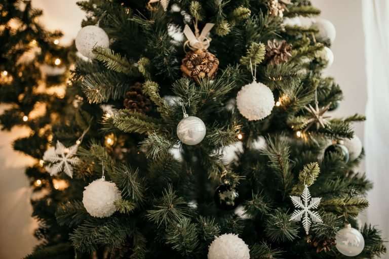 Close up of a Christmas tree with white baubles and snowflakes